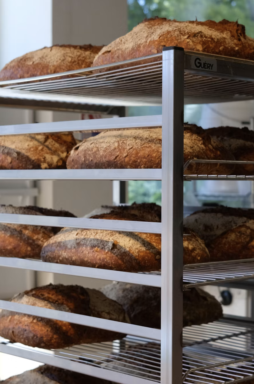 Croissants y brioche sobre mesa de panadería con bolsa de huevo en polvo y huevos frescos